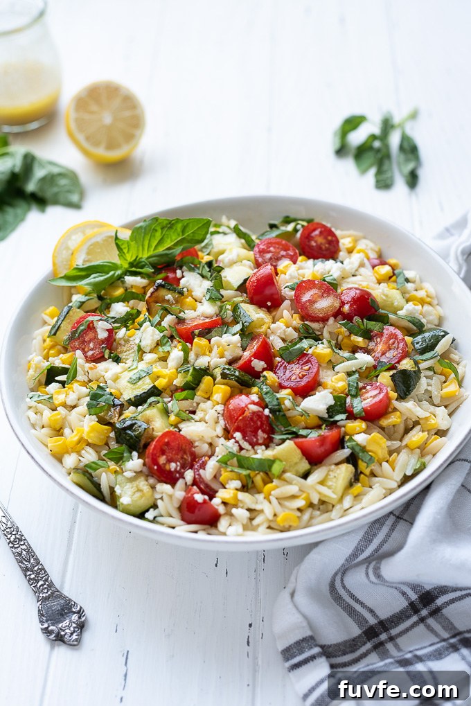 Orzo pasta salad in a bowl with linen alongside