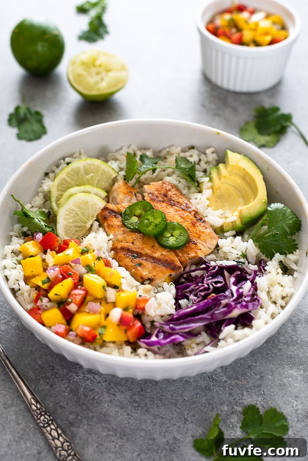angled overhead shot of fish taco bowl over rice with toppings