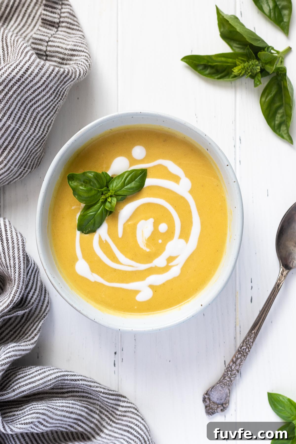 Summer squash soup with swirls of coconut milk and basil on top