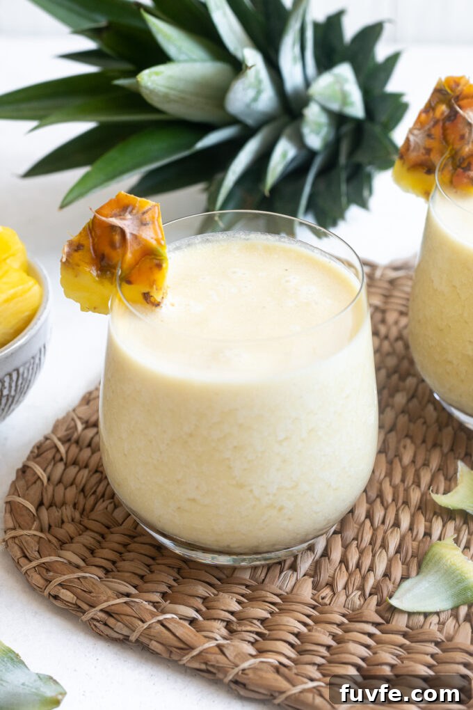 Easy pina colada in high ball glass with pineapple garnish.