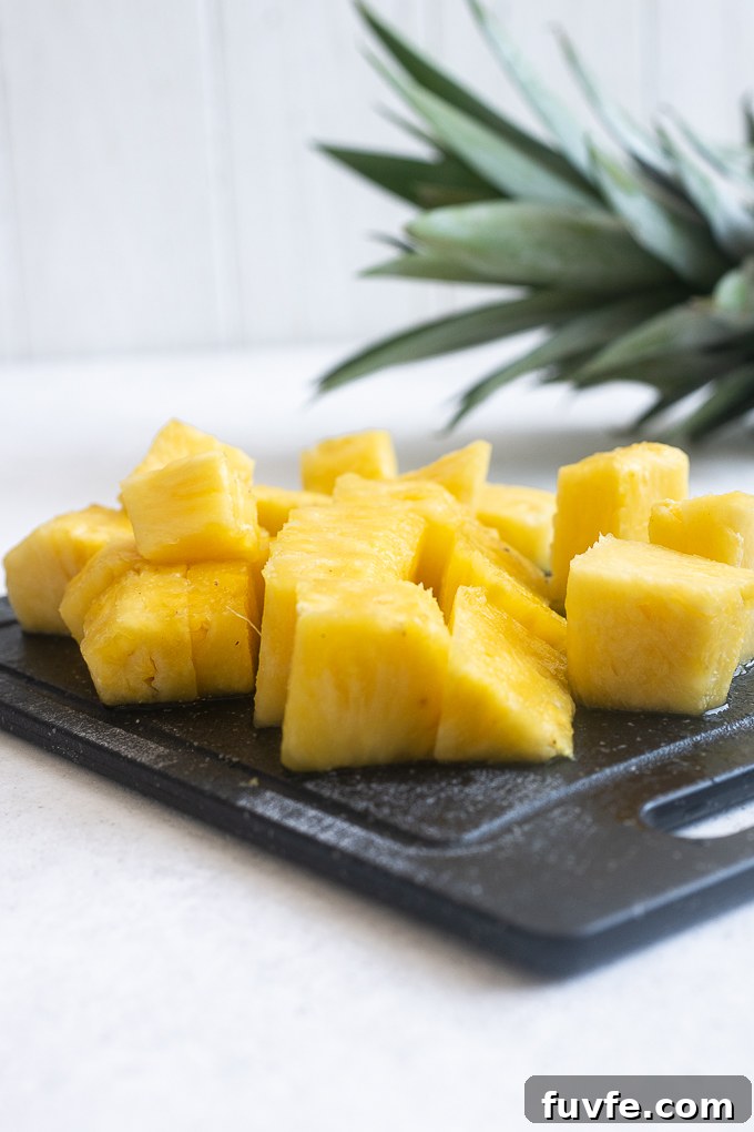 Fresh pineapple chunks on a cutting board.