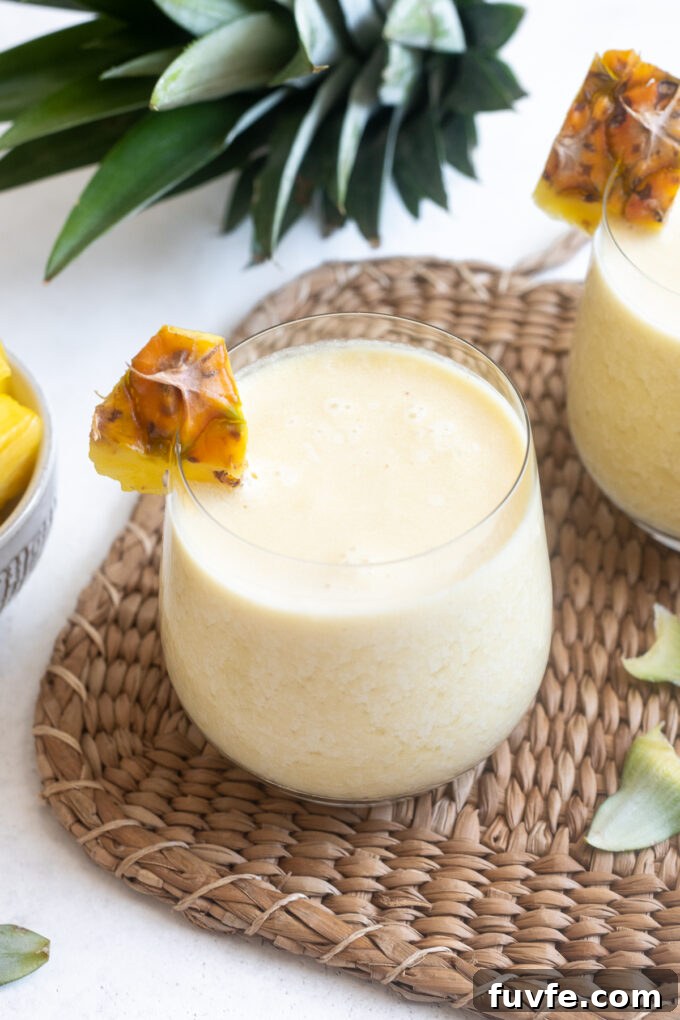 Classic Piña Colada Cocktail Recipe 9 Easy pina colada in a high ball glass with pineapple garnish.