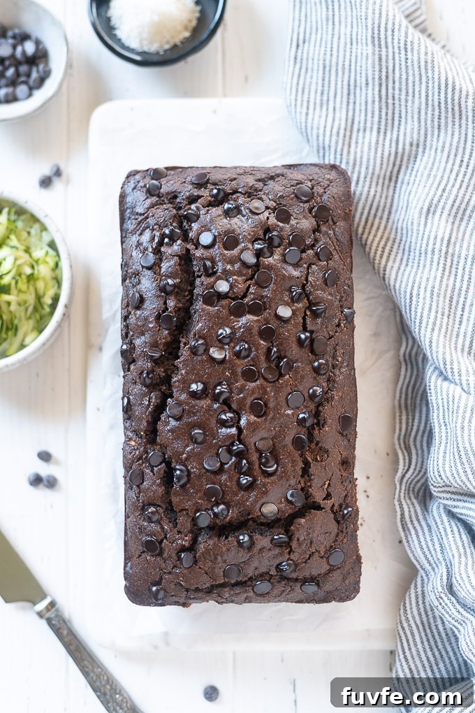 Loaf of double chocolate zucchini bread with a knife alongside