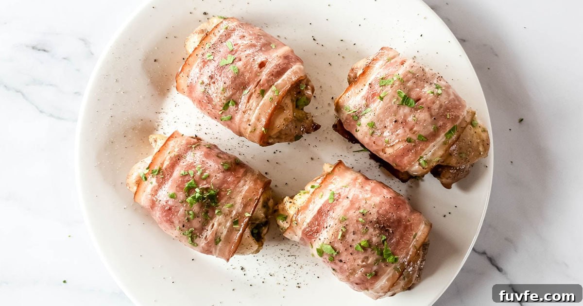 Four bacon wrapped chicken thighs with parsley garnish.