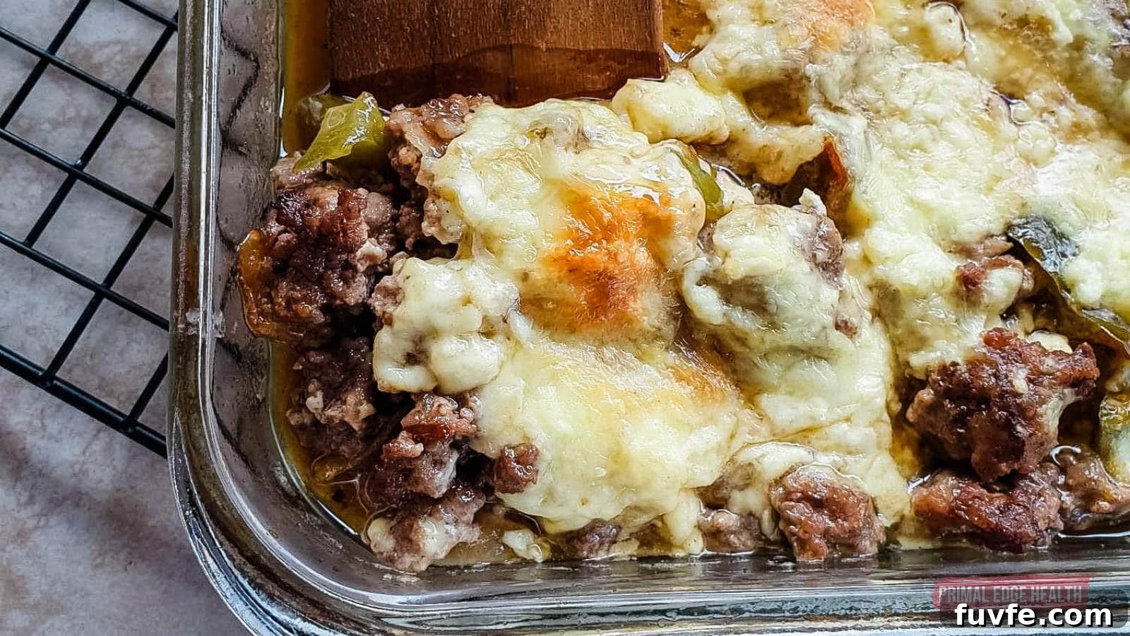A close-up of a baked casserole dish filled with melted cheese and ground meat, placed on a cooling rack.