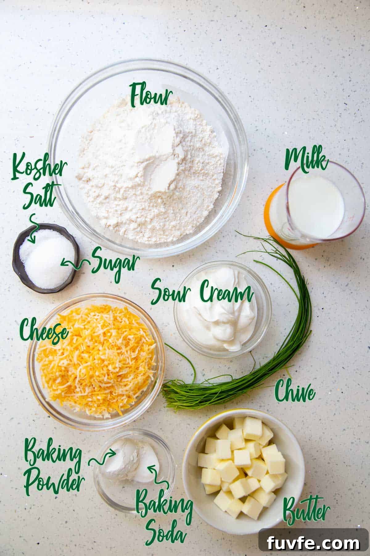 Ingredients for cheese biscuits on a white countertop.