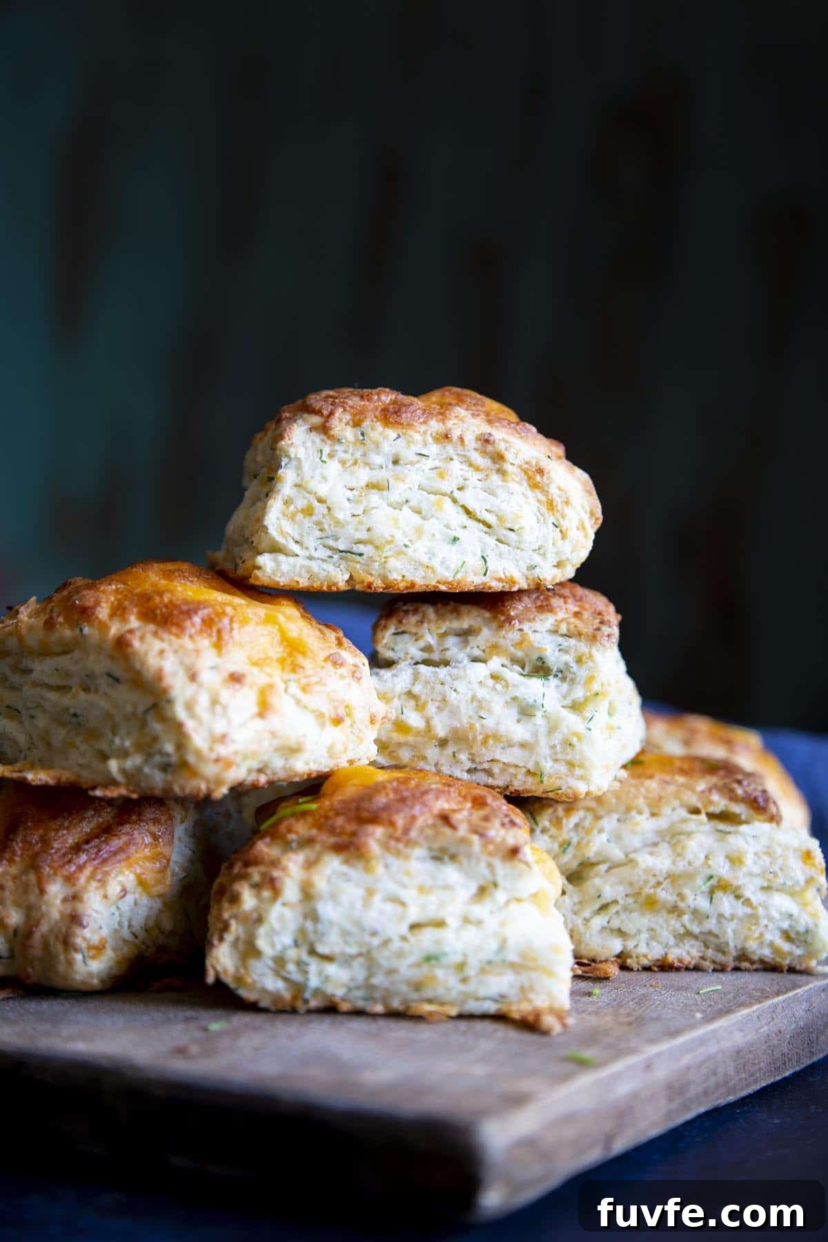 A stack of cheese biscuits on a wooden board.