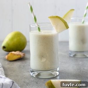Silky Pear and Ginger Smoothie Recipe 8 Pear smoothie in glass with striped straw and slice of pear