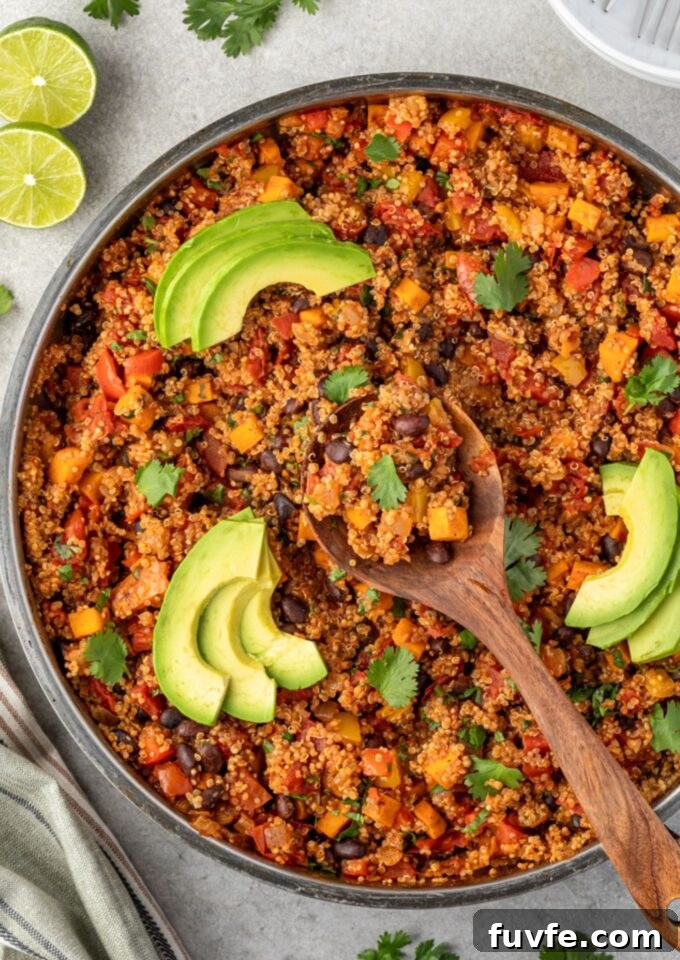 Mexican quinoa in a pan with wooden spoon in center