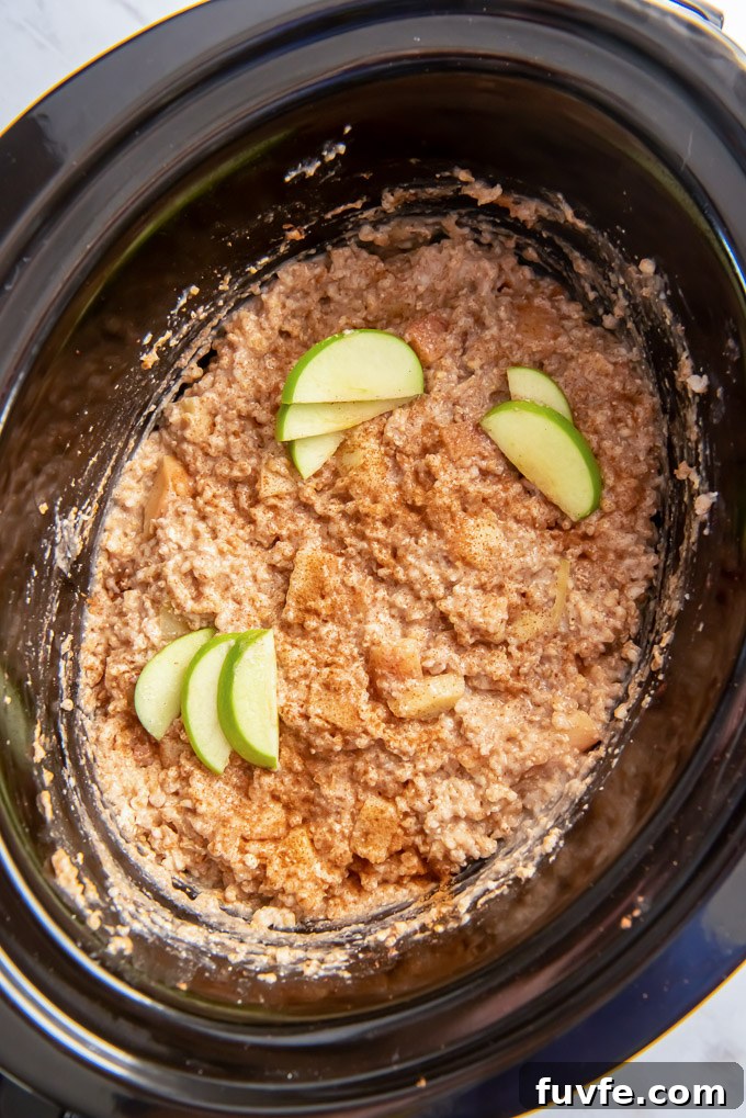Crockpot steel cut oats in the slow cooker with apple slices on top