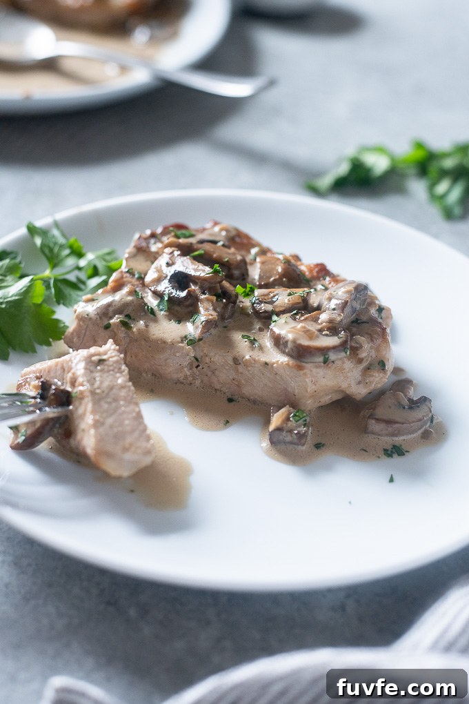 Pork chop on a plate with mushroom cream sauce