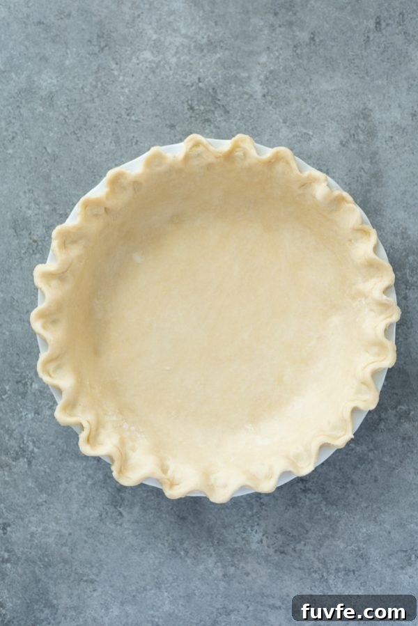 close up overhead shot of flaky pie crust in pie plate