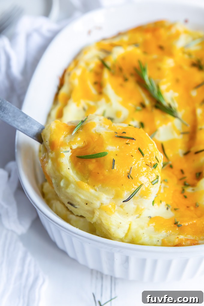 Serving spoon digging into twice baked mashed potatoes