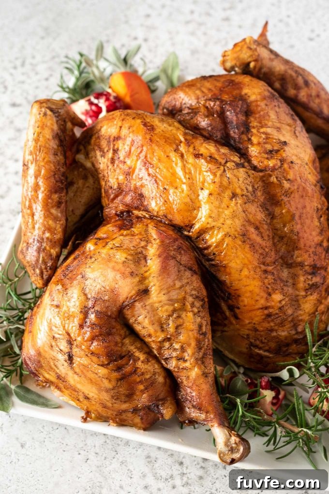 Spatchcock turkey on serving plate with herbs and pomegranate
