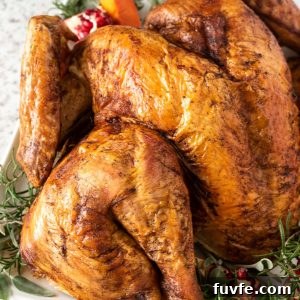 Spatchcock turkey on serving plate with herbs and pomegranate