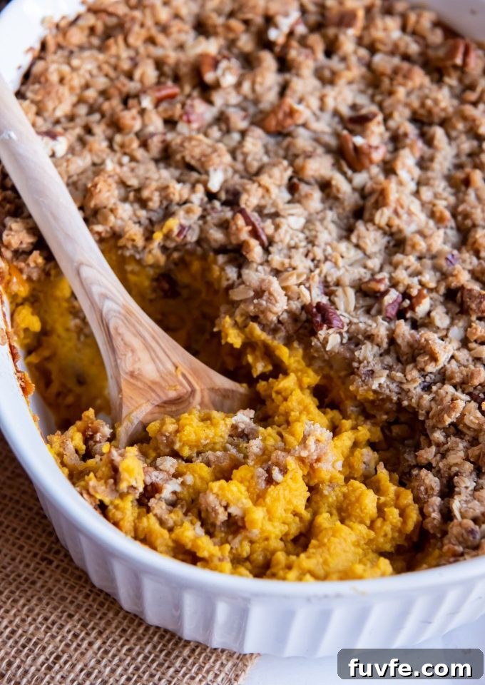 Wooden spoon digging into Butternut Squash Casserole