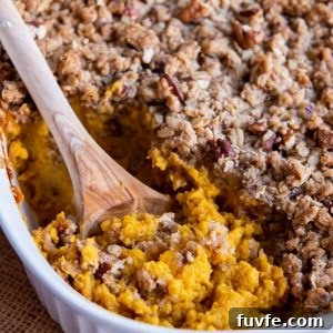 Wooden spoon digging into Butternut Squash Casserole