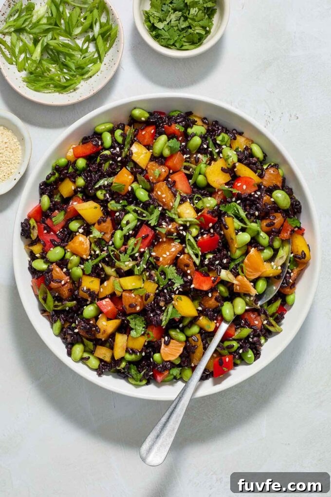 Asian black rice salad in a bowl with serving spoon.