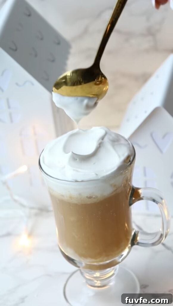 How to Make Butterbeer at Home: Harry Potter Recipe Tutorial 4 the harry potter butterbeer recipe in a tall drinking class with whipped cream on topo