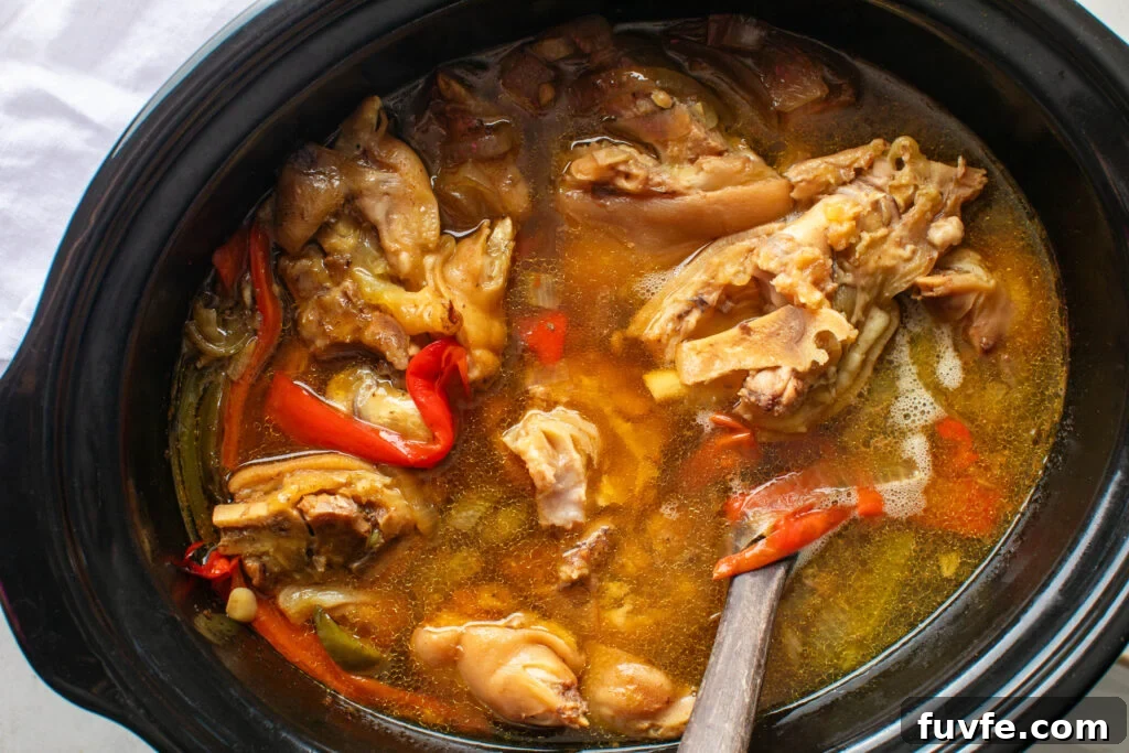 Cooked Pigs Feet and vegetables in crockpot.
