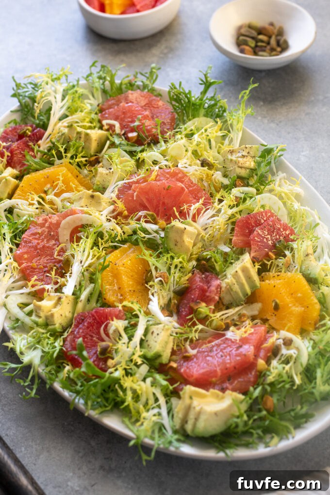 Citrus Frisee Salad with Fennel and Avocado 7 Citrus Frisée Salad on a platter with avocado and pistachios.