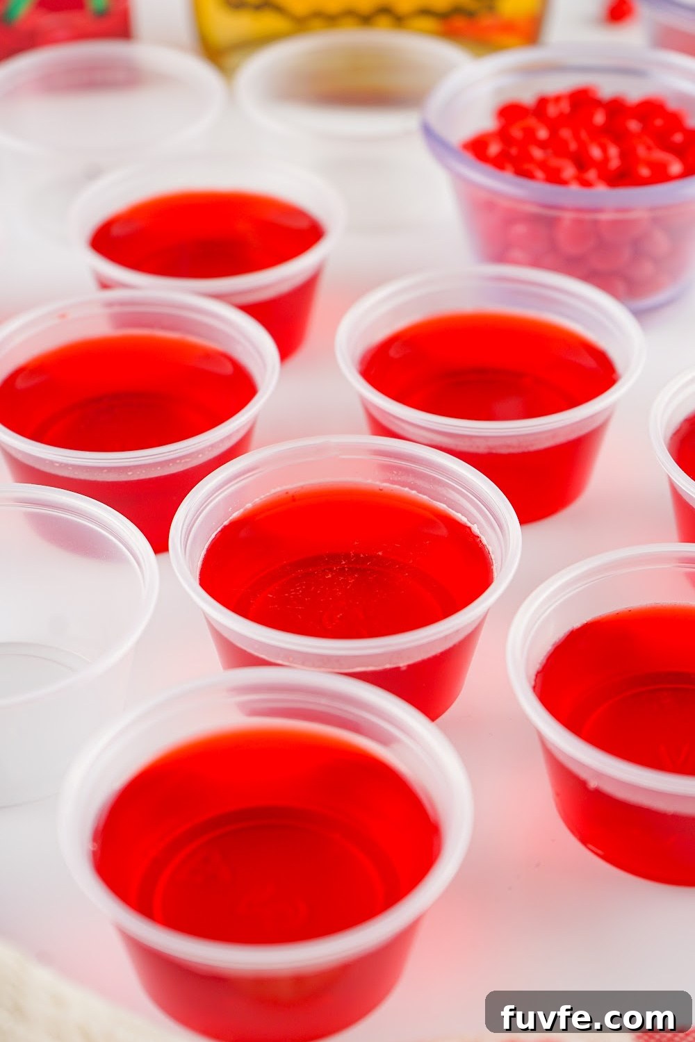 Process shot of cherry fireball jello shots.