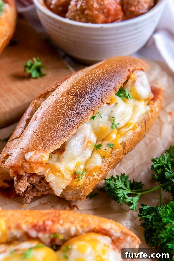 Slow Cooker BBQ Meatball Subs Recipe 8 Crockpot bbq meatball subs on a cutting board with bite out of one