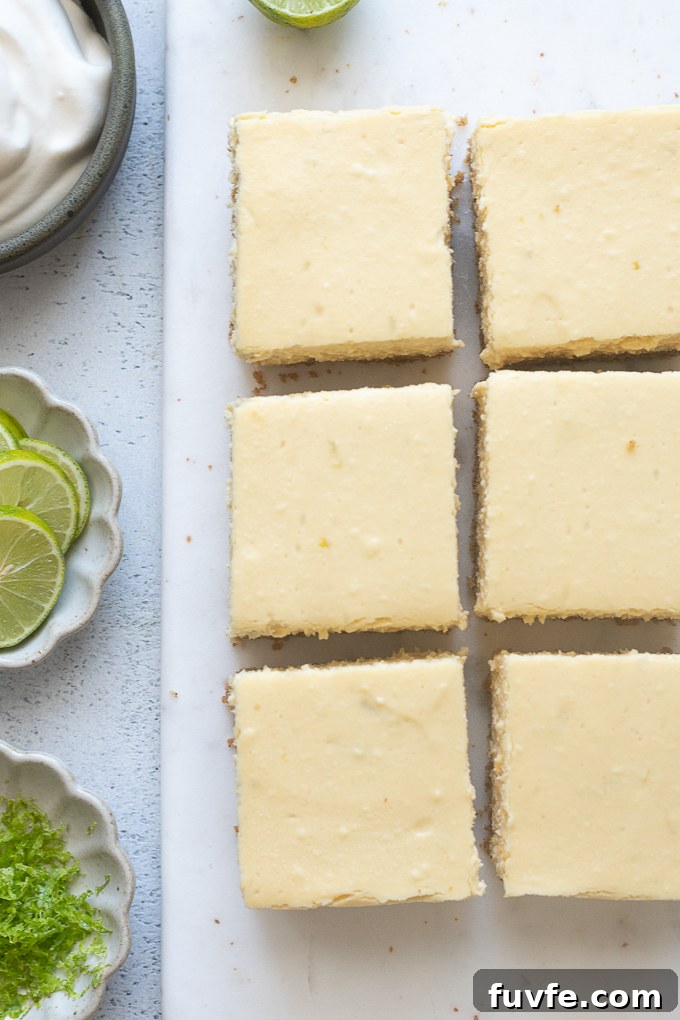Cooled cheesecake bars cut into squares.