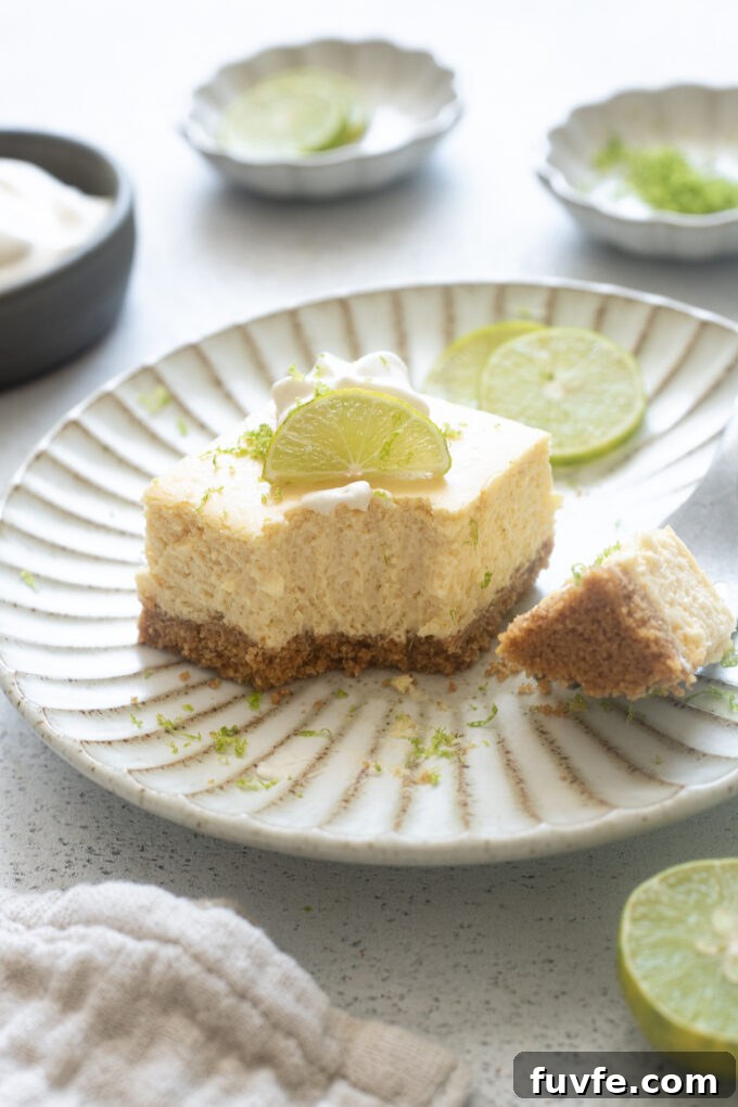 Key lime cheesecake bar on a plate with bite out of it.