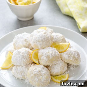 Meyer Lemon Kourabiedes Recipe: Greek Butter Cookies 8 Meyer lemon Greek butter cookies on a plate with lemon slices.